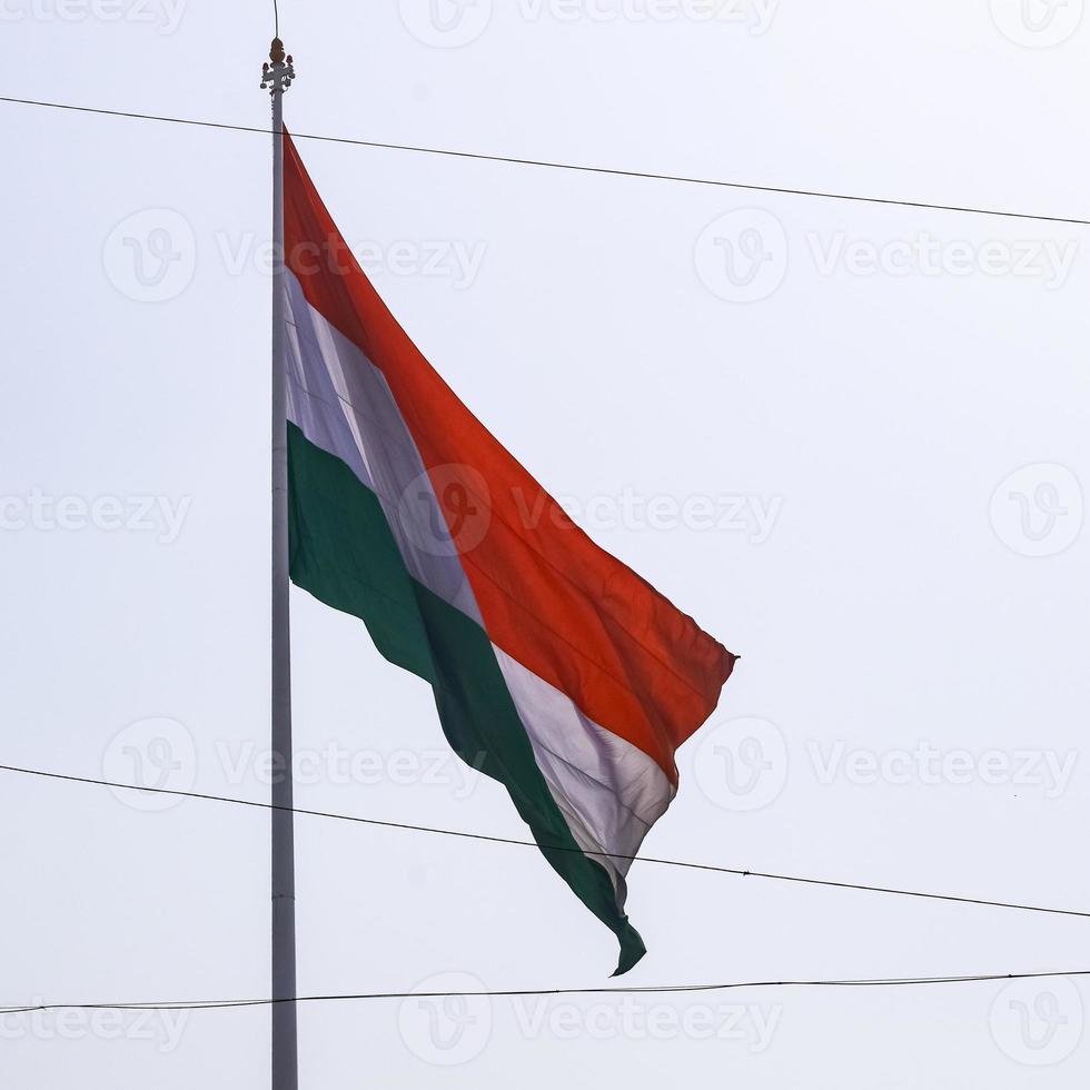 India flag flying high at Connaught Place with pride in blue sky, India flag fluttering, Indian Flag on Independence Day and Republic Day of India, tilt up shot, waving Indian flag, Flying India flags photo