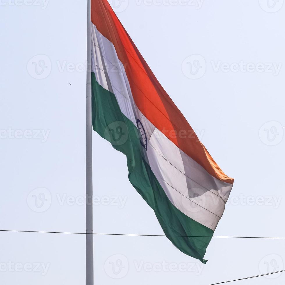 India flag flying high at Connaught Place with pride in blue sky, India flag fluttering, Indian Flag on Independence Day and Republic Day of India, tilt up shot, waving Indian flag, Flying India flags photo