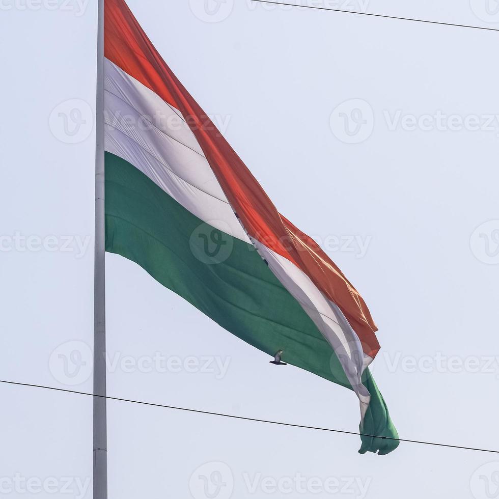 India flag flying high at Connaught Place with pride in blue sky, India flag fluttering, Indian Flag on Independence Day and Republic Day of India, tilt up shot, waving Indian flag, Flying India flags photo