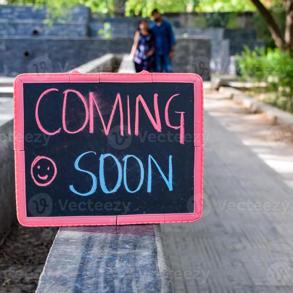 Indian couple posing for maternity baby shoot. The couple is posing in a lawn with green grass and the woman is falunting her baby bump in Lodhi Garden in New Delhi, India photo