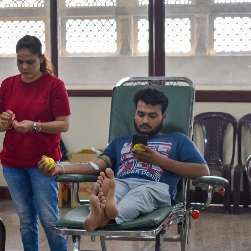 Delhi, India, June 19 2022 - Blood donor at Blood donation camp held at Balaji Temple, Vivek Vihar, Delhi, India, Image for World blood donor day on June 14 every year, Blood Donation Camp at Temple photo