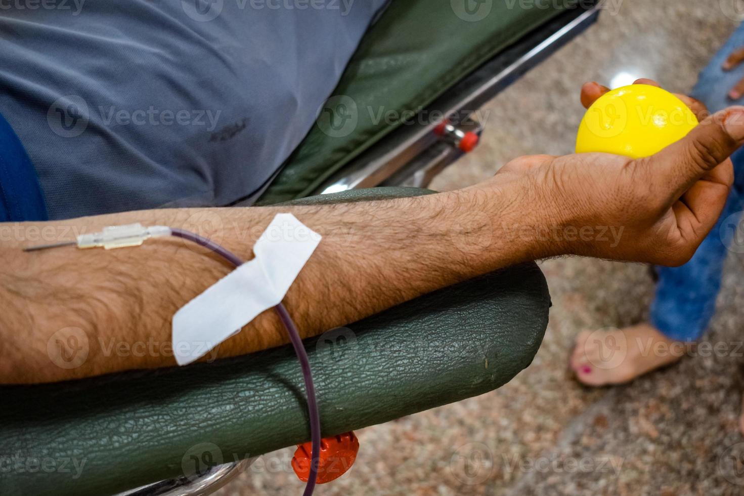Blood donor at Blood donation camp held with a bouncy ball holding in hand at Balaji Temple, Vivek Vihar, Delhi, India, Image for World blood donor day on June 14 every year, Blood Donation Camp photo