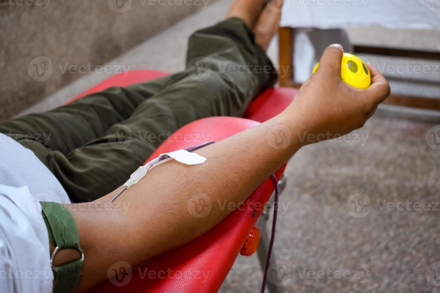 Blood donor at Blood donation camp held with a bouncy ball holding in hand at Balaji Temple, Vivek Vihar, Delhi, India, Image for World blood donor day on June 14 every year, Blood Donation Camp photo