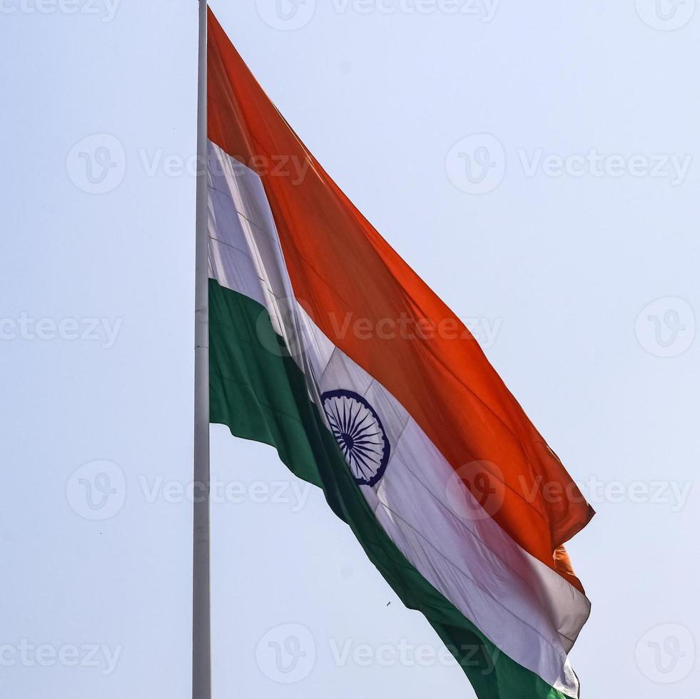 India flag flying high at Connaught Place with pride in blue sky, India flag fluttering, Indian Flag on Independence Day and Republic Day of India, tilt up shot, waving Indian flag, Flying India flags photo