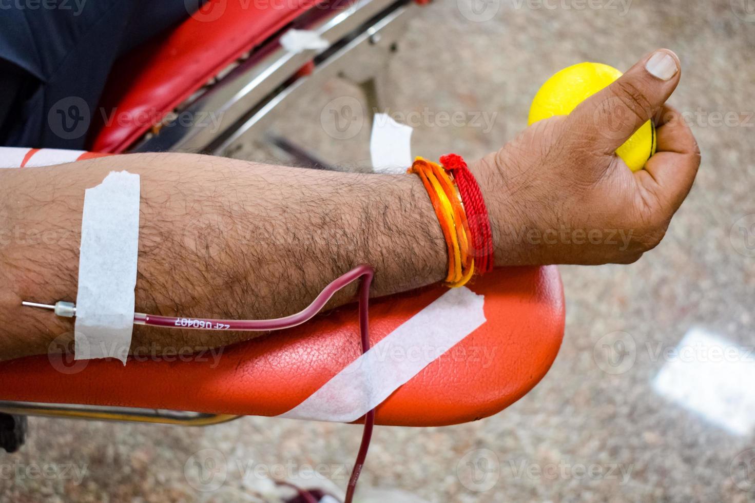 Blood donor at Blood donation camp held with a bouncy ball holding in hand at Balaji Temple, Vivek Vihar, Delhi, India, Image for World blood donor day on June 14 every year, Blood Donation Camp photo