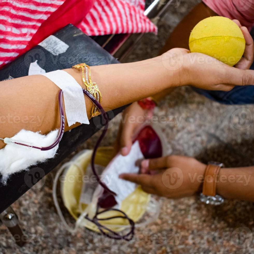 donante de sangre en el campamento de donación de sangre sostenido con una pelota hinchable en la mano en el templo balaji, vivek vihar, delhi, india, imagen para el día mundial del donante de sangre el 14 de junio de cada año, campamento de donación de sangre foto