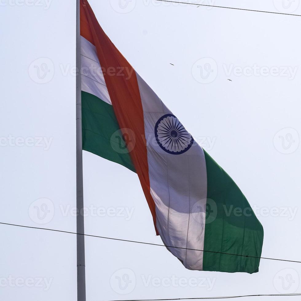 India flag flying high at Connaught Place with pride in blue sky, India flag fluttering, Indian Flag on Independence Day and Republic Day of India, tilt up shot, waving Indian flag, Flying India flags photo