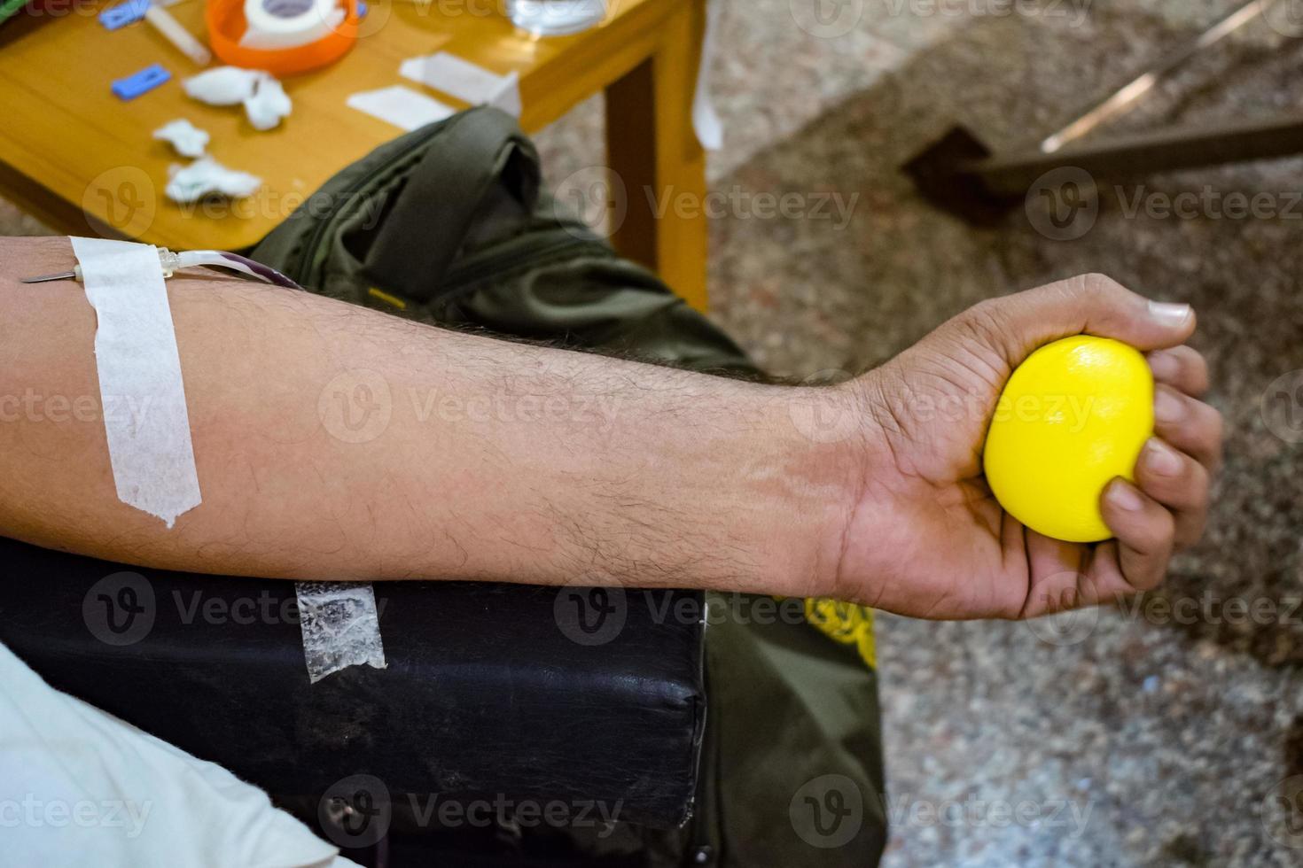 Blood donor at Blood donation camp held with a bouncy ball holding in hand at Balaji Temple, Vivek Vihar, Delhi, India, Image for World blood donor day on June 14 every year, Blood Donation Camp photo