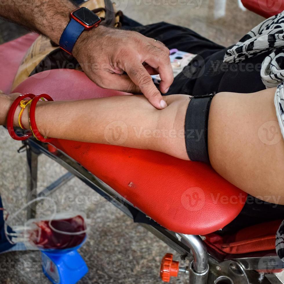 donante de sangre en el campamento de donación de sangre sostenido con una pelota hinchable en la mano en el templo balaji, vivek vihar, delhi, india, imagen para el día mundial del donante de sangre el 14 de junio de cada año, campamento de donación de sangre foto