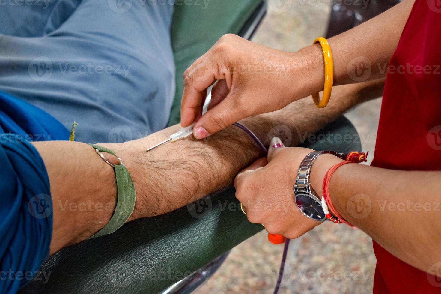 donante de sangre en el campamento de donación de sangre sostenido con una pelota hinchable en la mano en el templo balaji, vivek vihar, delhi, india, imagen para el día mundial del donante de sangre el 14 de junio de cada año, campamento de donación de sangre foto