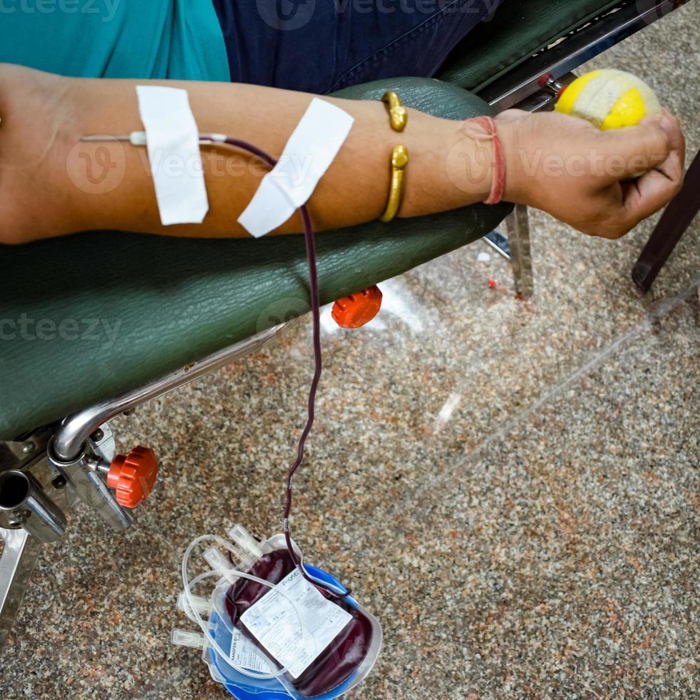 Blood donor at Blood donation camp held with a bouncy ball holding in hand at Balaji Temple, Vivek Vihar, Delhi, India, Image for World blood donor day on June 14 every year, Blood Donation Camp photo