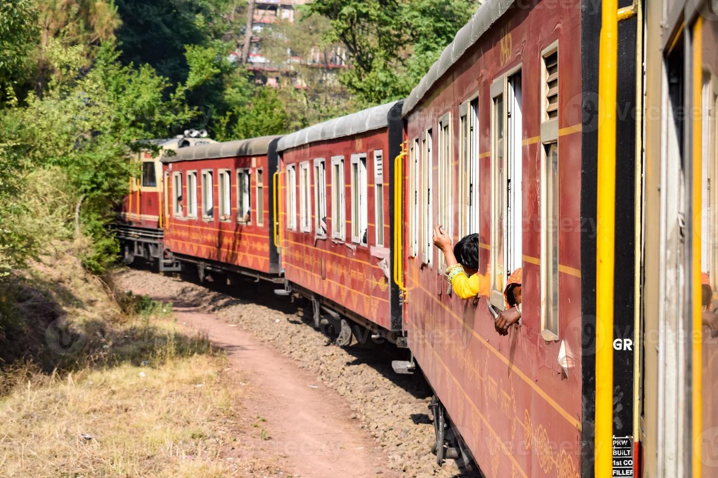 tren de juguete moviéndose en las laderas de las montañas, hermosa vista, una montaña lateral, un valle lateral moviéndose en ferrocarril hacia la colina, entre bosques naturales verdes. tren de juguete de kalka a shimla en india, tren indio foto