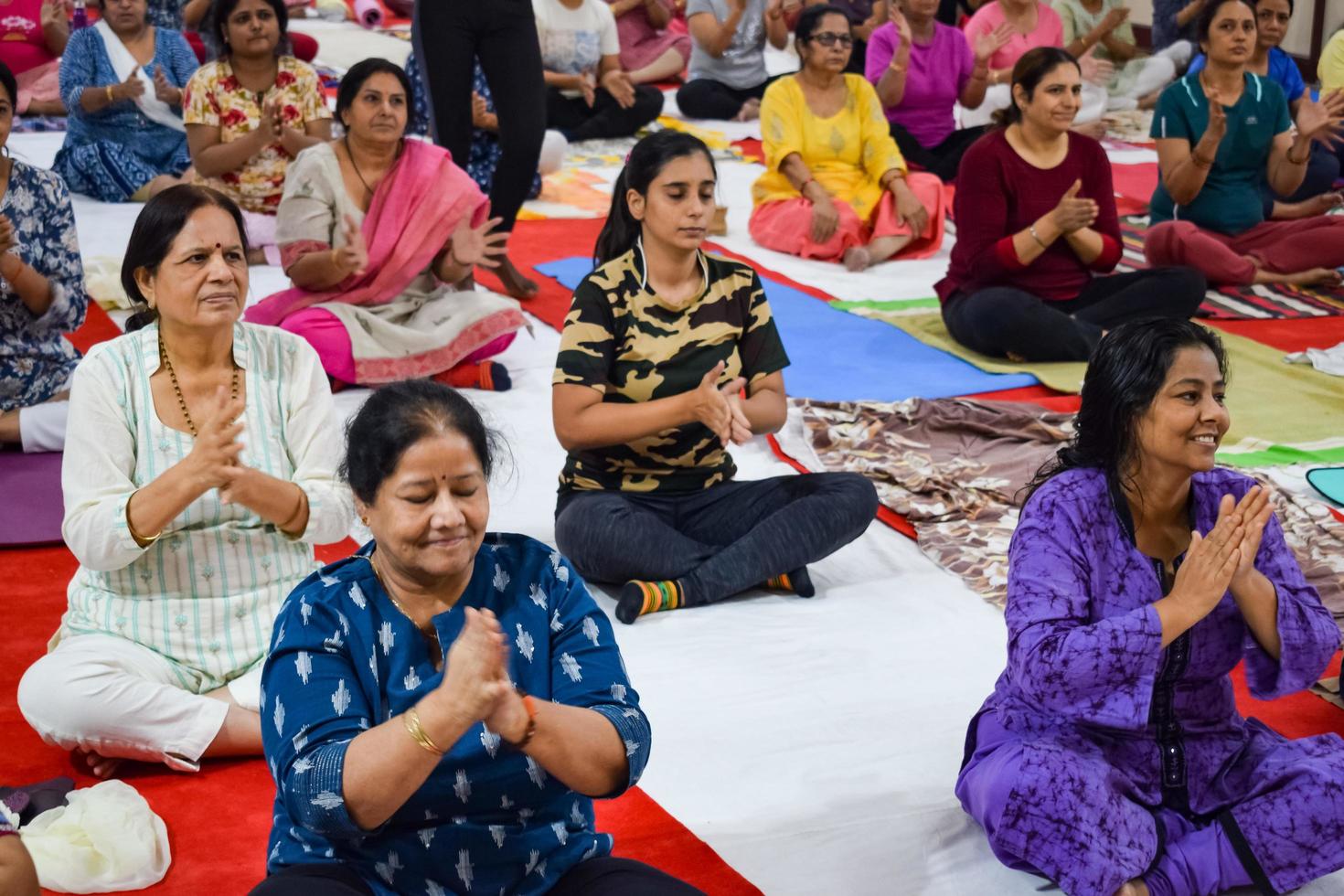 New Delhi, India, June 19 2022 -Group Yoga exercise session for people of different age groups in Balaji Temple, Vivek Vihar, International Yoga Day, Big group of adults attending yoga class in temple photo