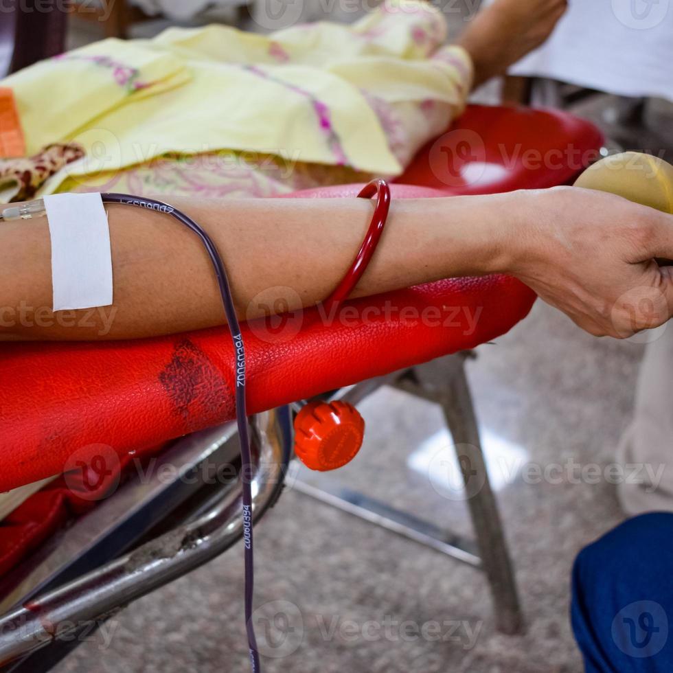 donante de sangre en el campamento de donación de sangre sostenido con una pelota hinchable en la mano en el templo balaji, vivek vihar, delhi, india, imagen para el día mundial del donante de sangre el 14 de junio de cada año, campamento de donación de sangre foto