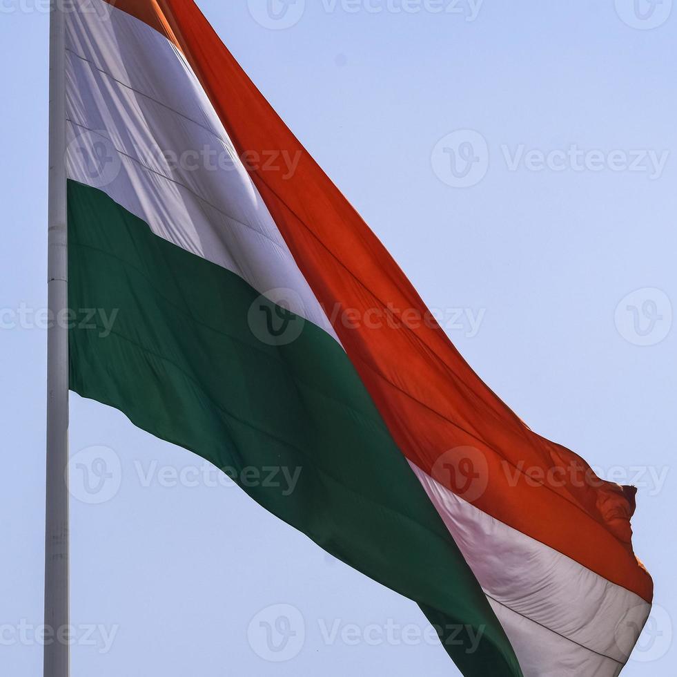 India flag flying high at Connaught Place with pride in blue sky, India flag fluttering, Indian Flag on Independence Day and Republic Day of India, tilt up shot, waving Indian flag, Flying India flags photo