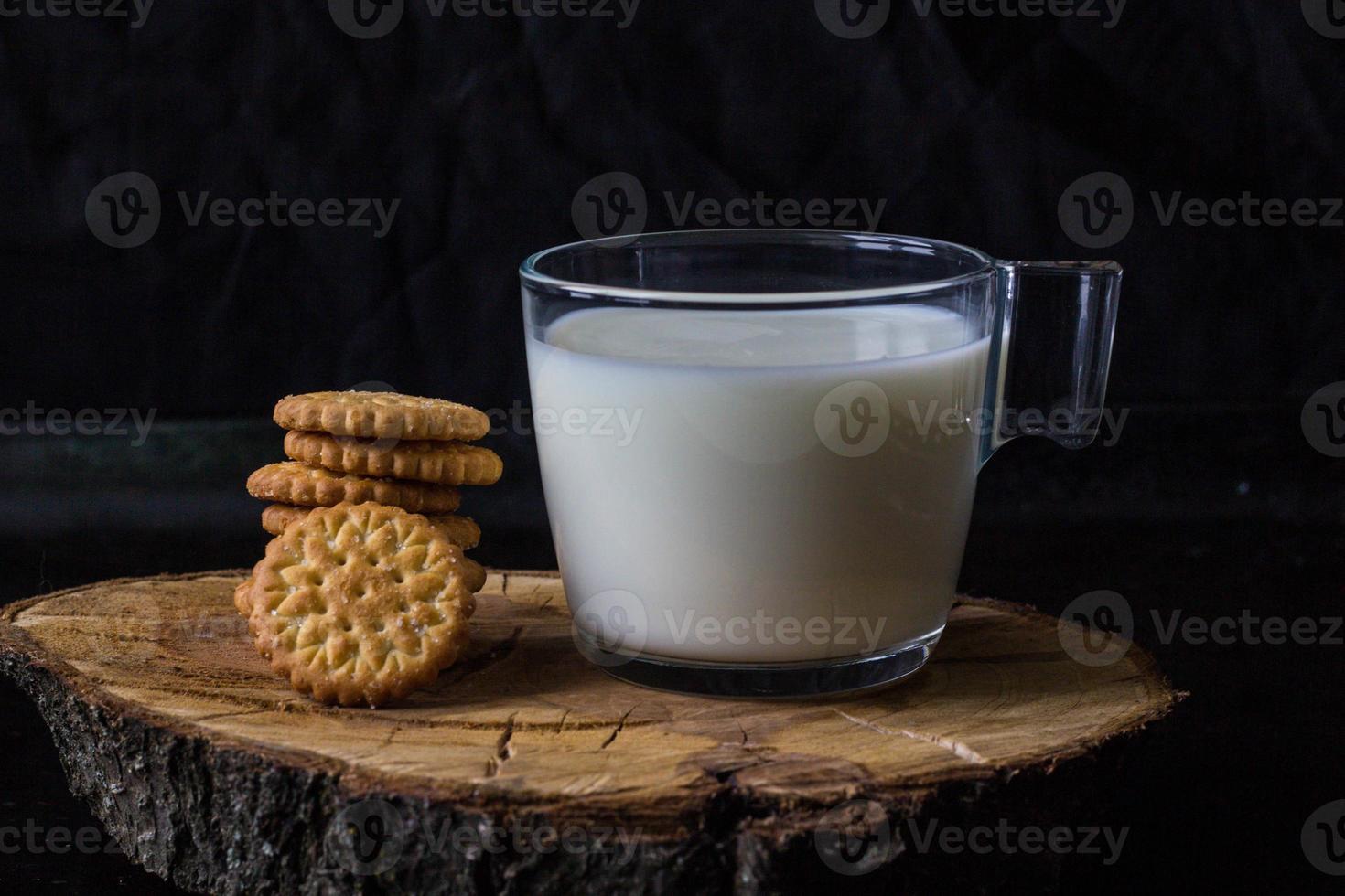fresh healthy milk and stack of cookies on black background photo
