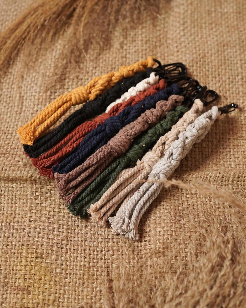 Macrame keychain, Macrame shot, handmade by women at home. Great DIY images for macrame and crafts banners and advertisements. creative hobby layout with accessories, top view. Handcrafted macrame. photo