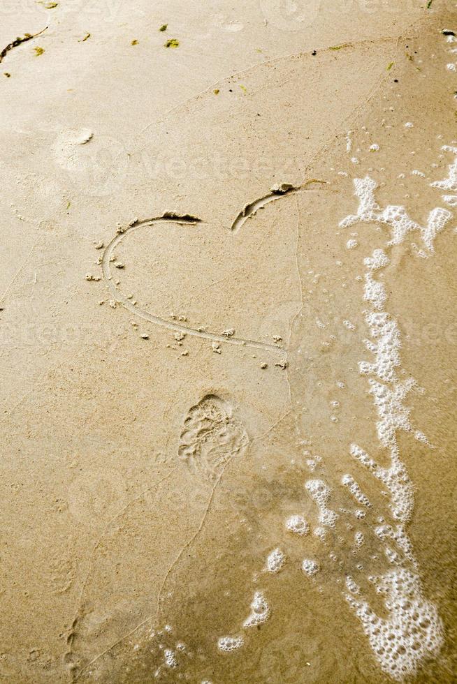 olas del mar borrando el dibujo de un corazón foto