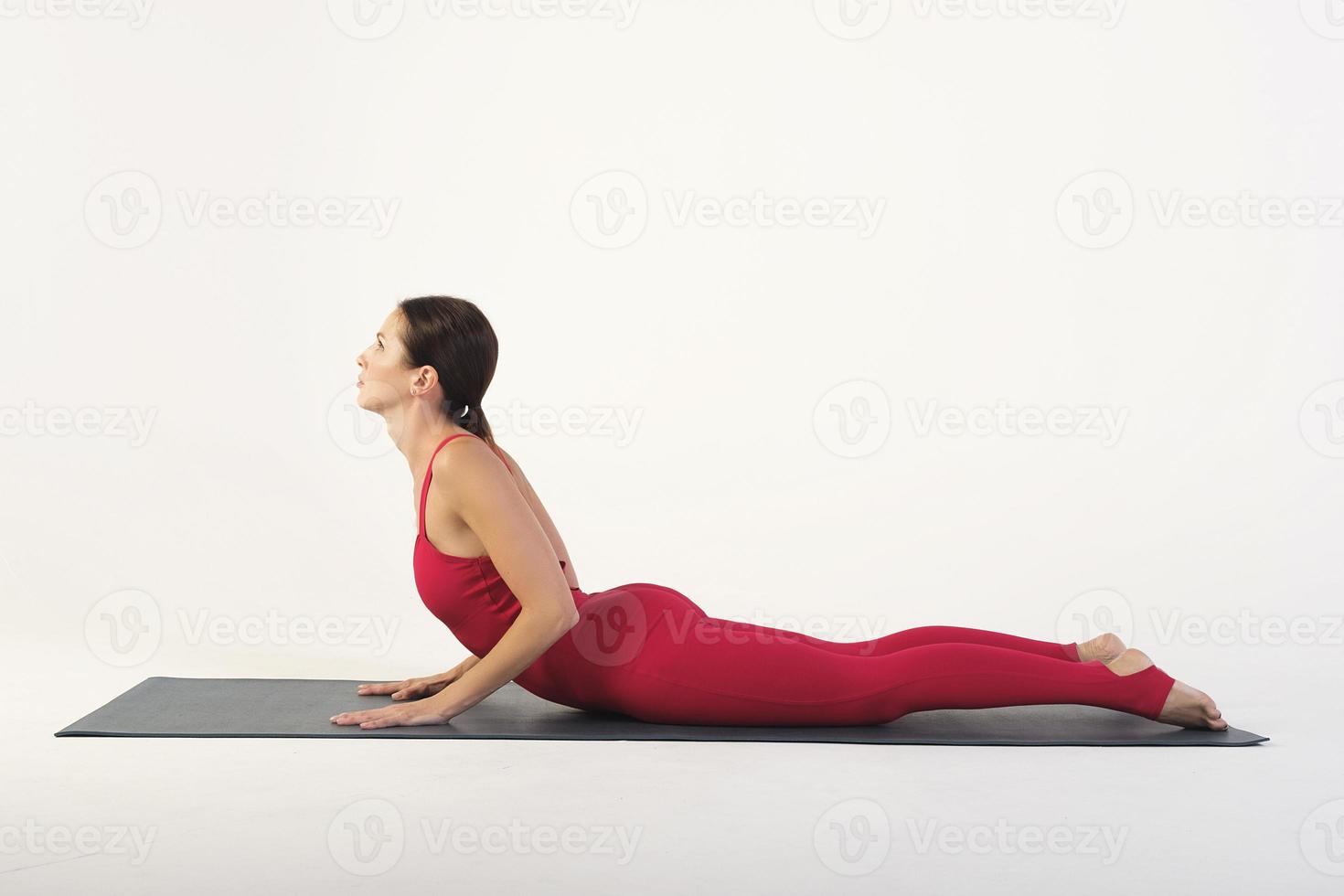 a charming girl demonstrates stretching and yoga asanas in a photo studio