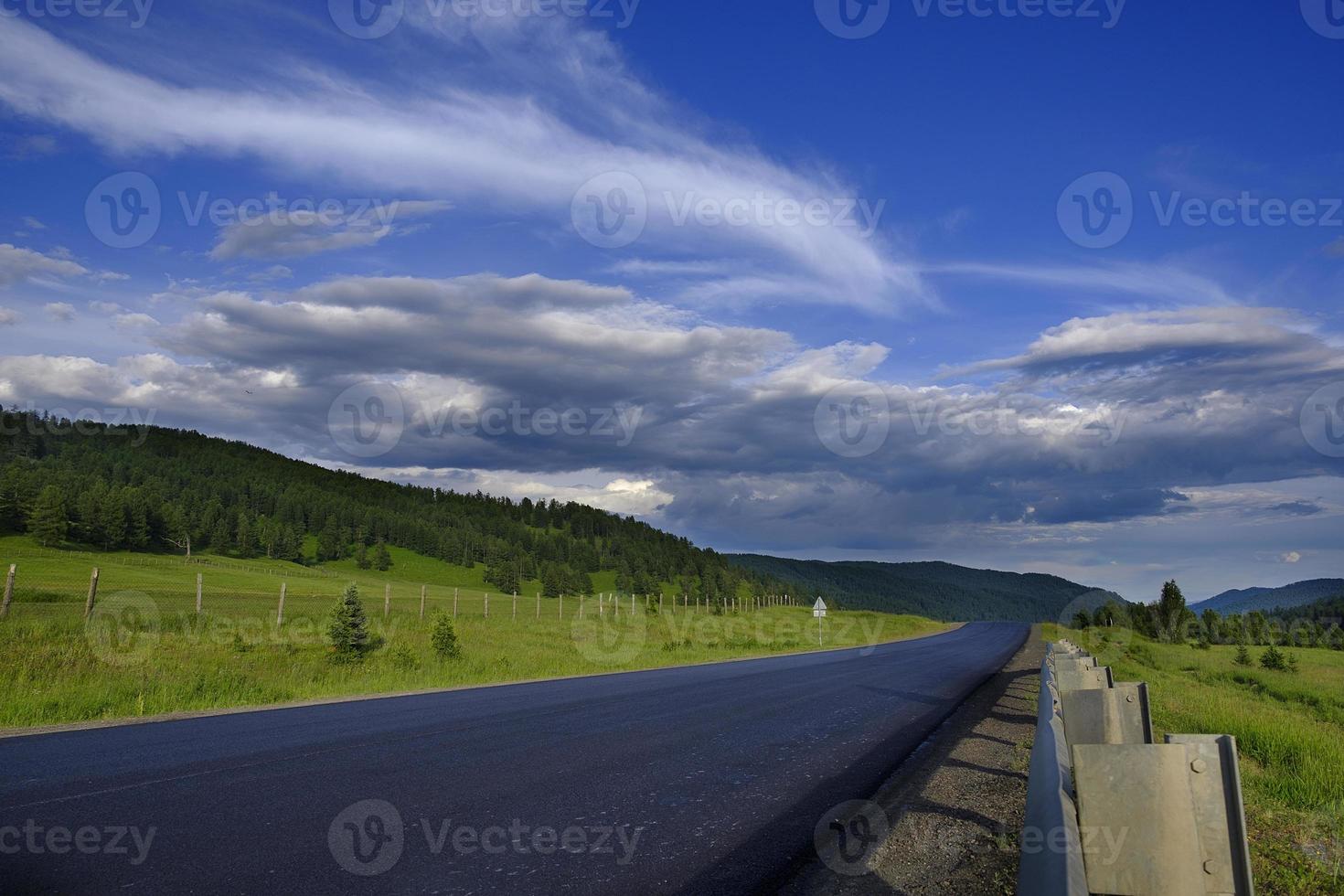 ribbon of the road among the slopes of the mountains on the expanses of Altai on a summer day photo