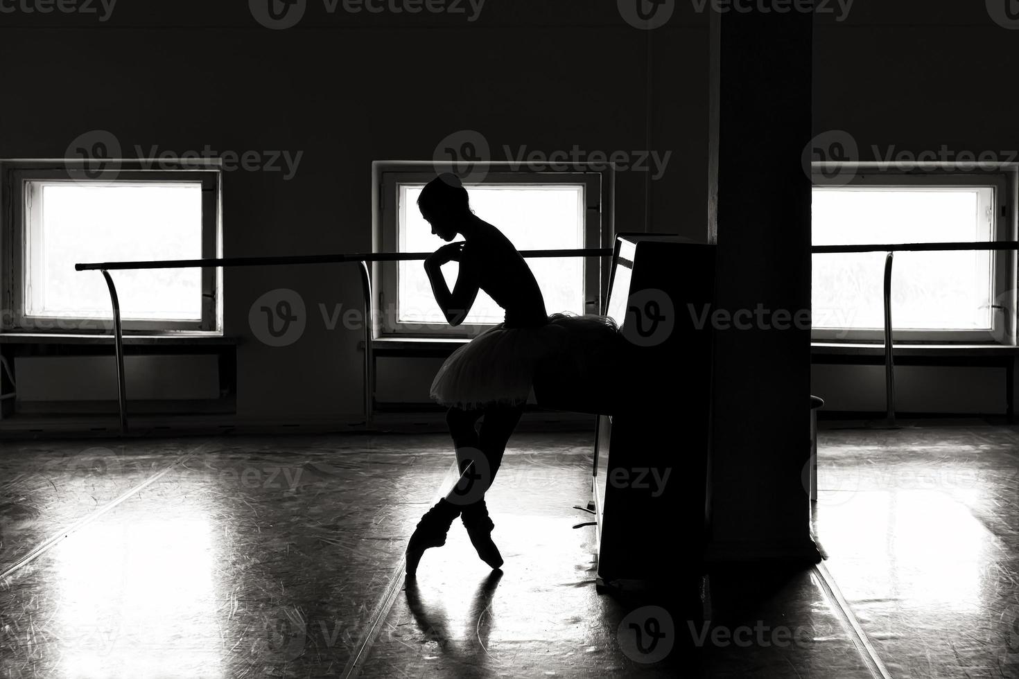 a charming ballerina in a bodysuit poses ballet elements in a headdress in a photo studio