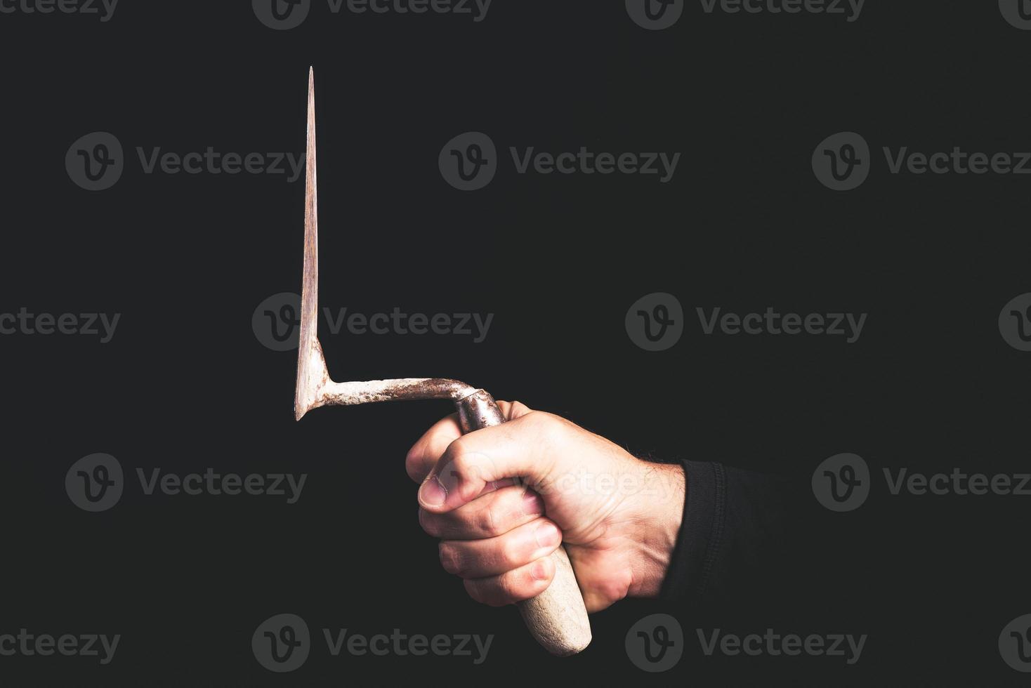 trowel in a man hand on black background - maintenance service concept photo