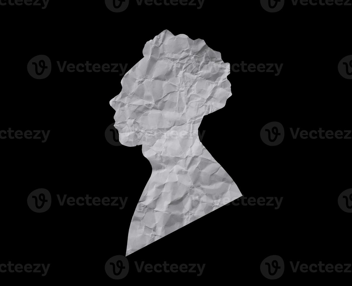 Human head silhouette with black background. People portrait with crumpled paper texture. Paper cut people from side angle. photo