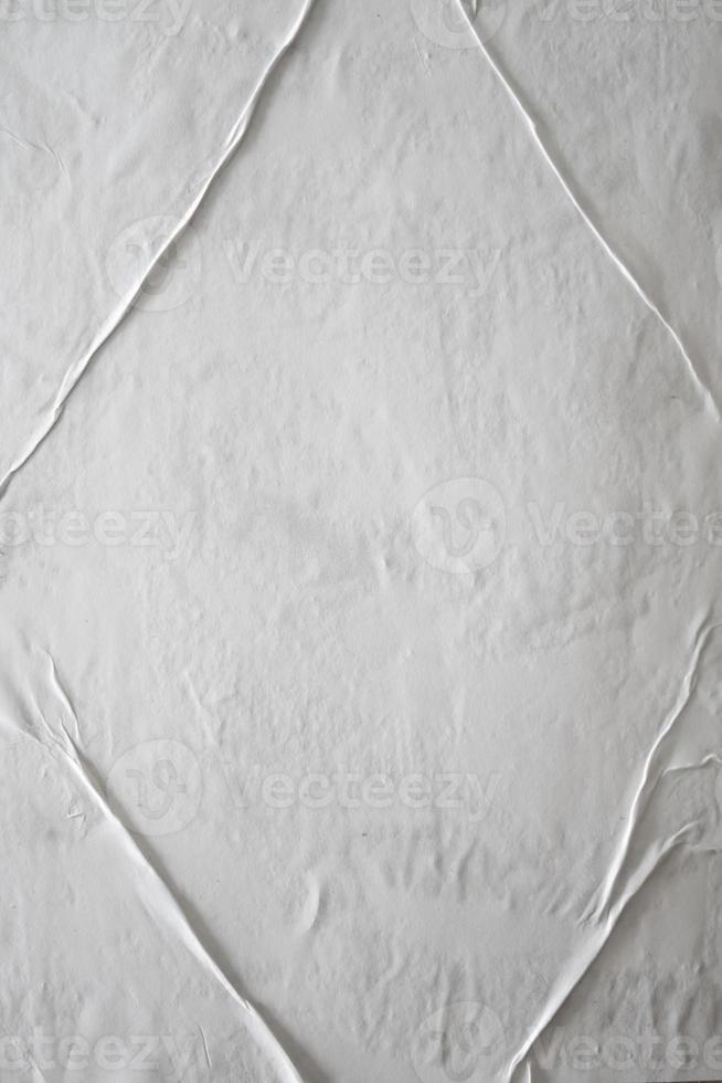 papel pegado blanco en blanco para superposición de textura de póster. patrón arrugado y arrugado para el fondo. papel mojado mate para carteles de maquetas, volantes, folletos y diseño de pancartas foto