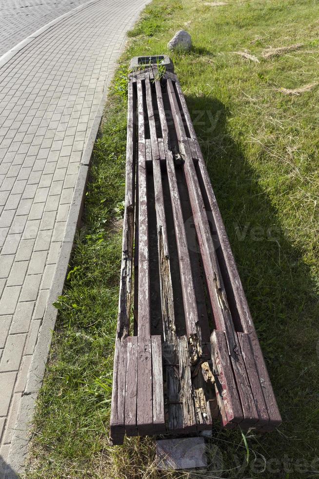 an old rotting wooden bench in the park photo