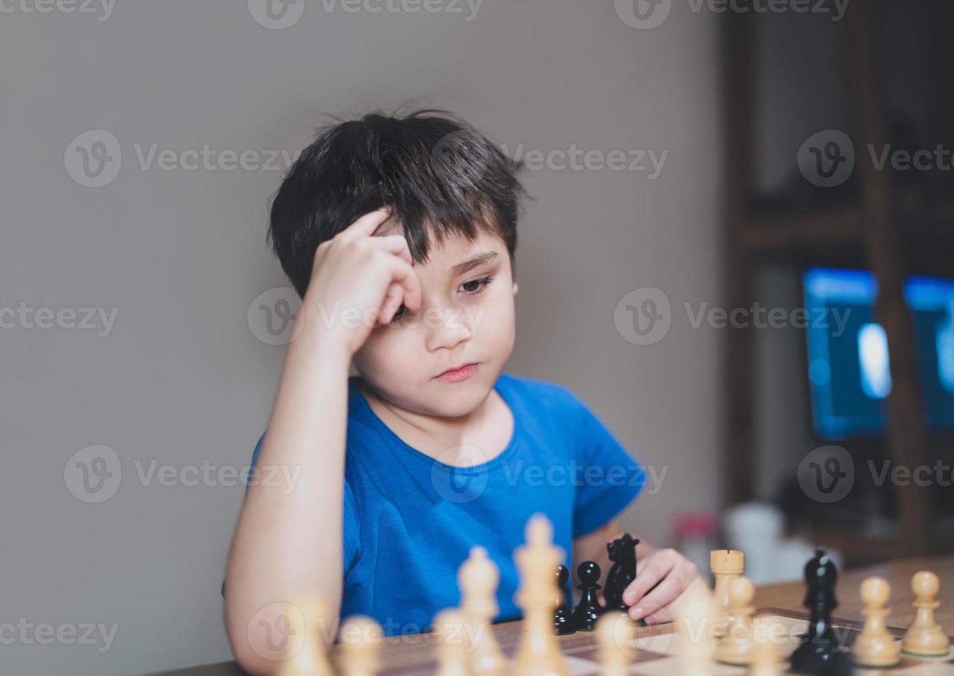 niño concentrado desarrollando estrategia de ajedrez, jugando juegos de mesa con sus padres en casa. actividad o pasatiempo por concepto de familia foto