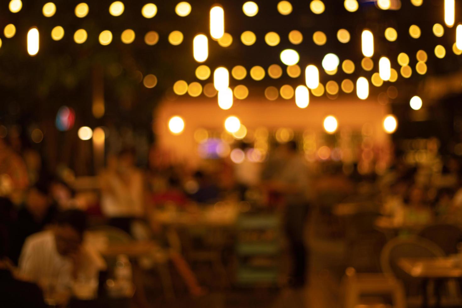 imagen borrosa en la noche del restaurante, muchas personas en el restaurante comen y se divierten felices relajándose foto