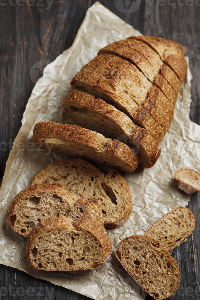 Sliced Rye Rustic Sourdough Bread on a Brown Paper. On a Wooden Table. T photo