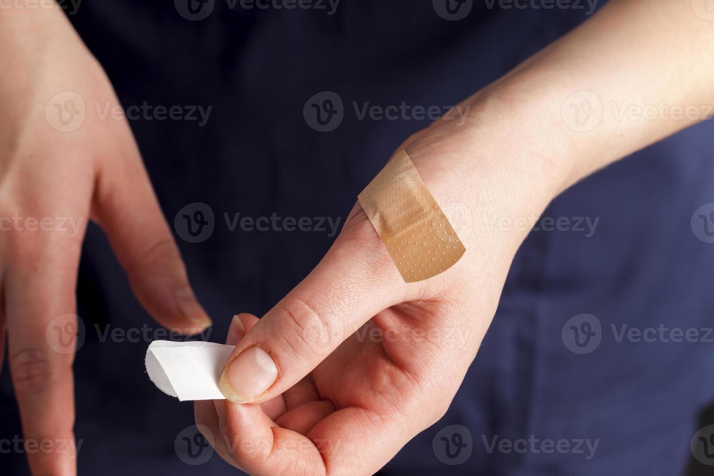 a woman in medical clothing puts a band on her hand photo