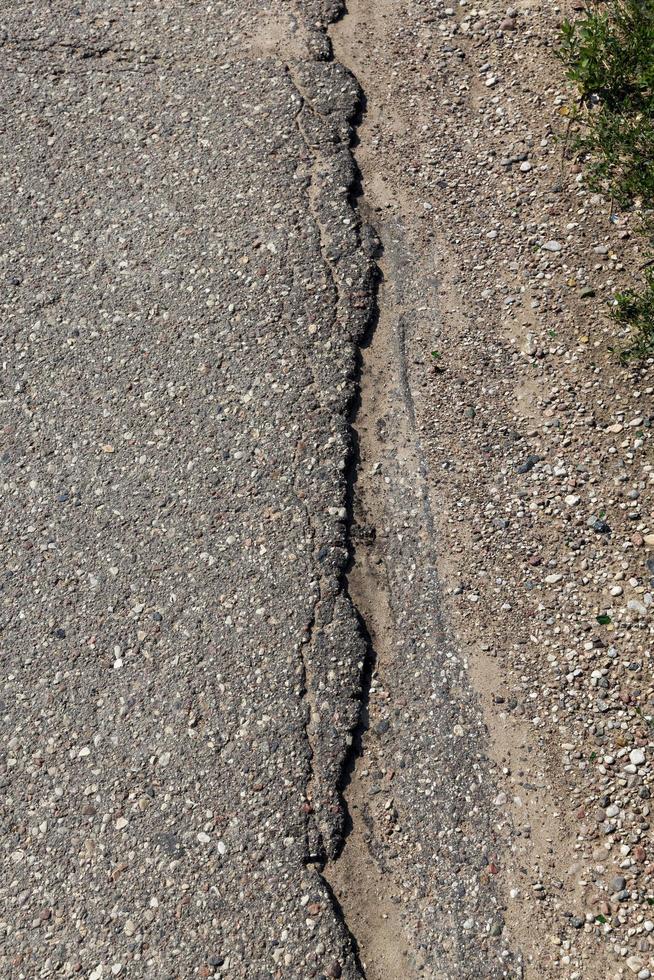 an asphalt road with a lot of holes and damage photo