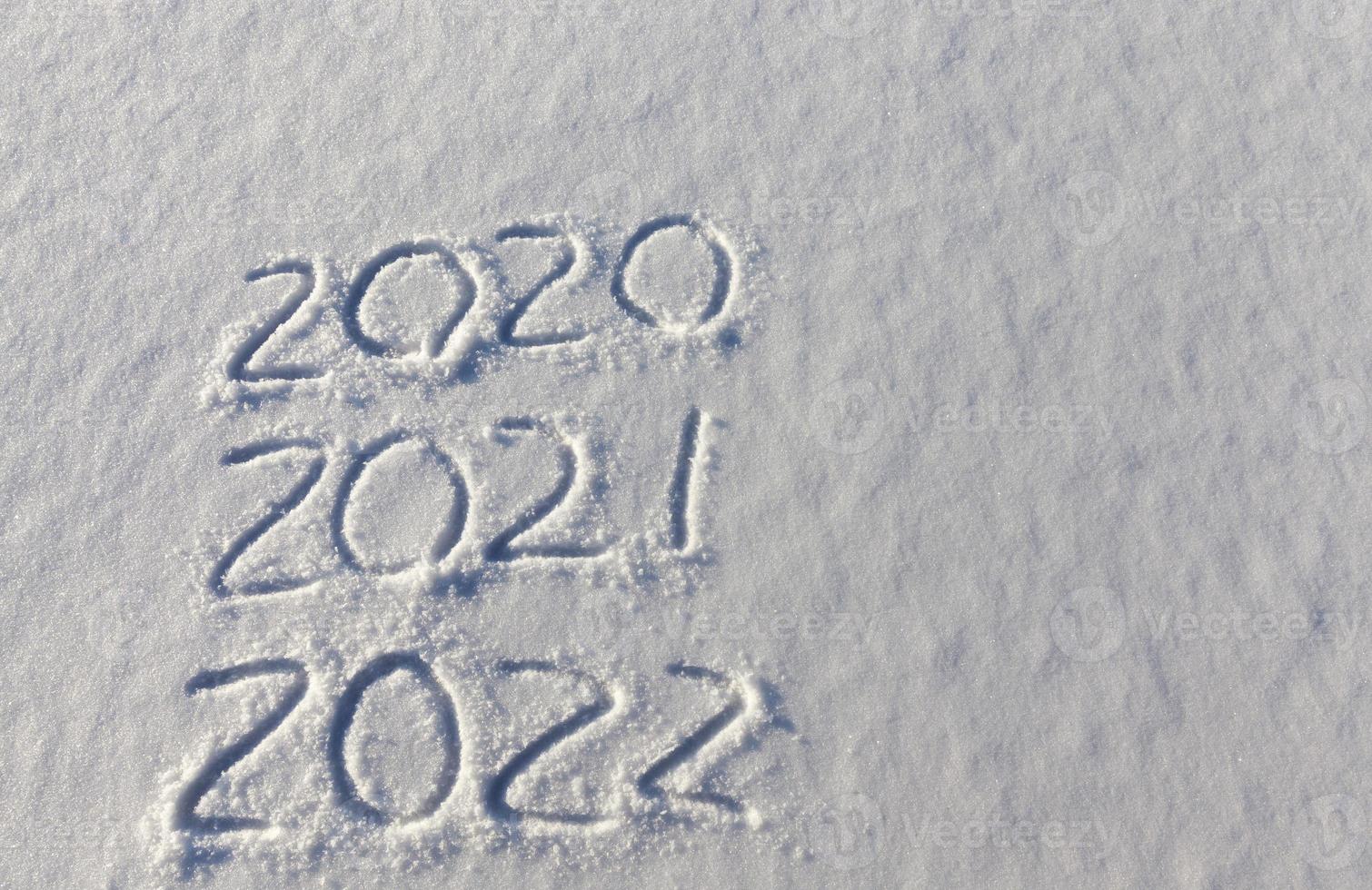 the inscription about the new year 2022 on the snow in winter photo