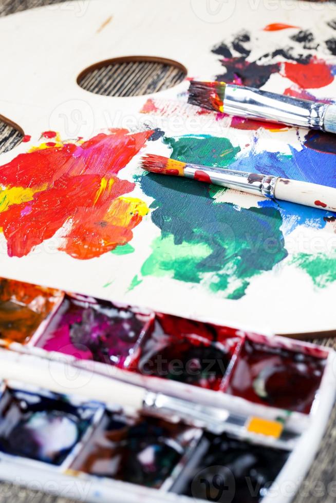 mixed on a wooden palette of multi colored paints photo