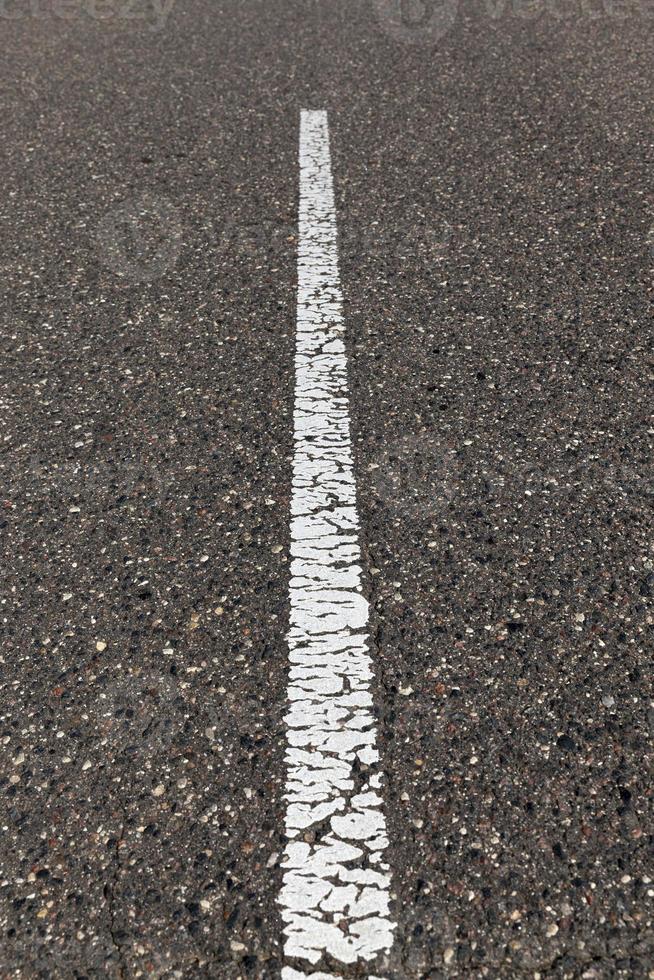 camino pavimentado con marcas viales blancas para la gestión del transporte foto