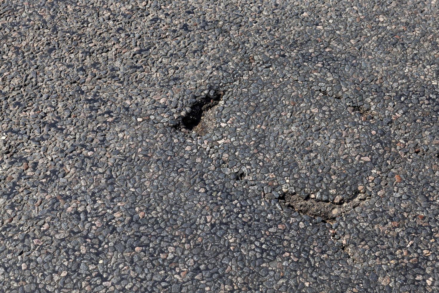 paved road with a lot of holes photo