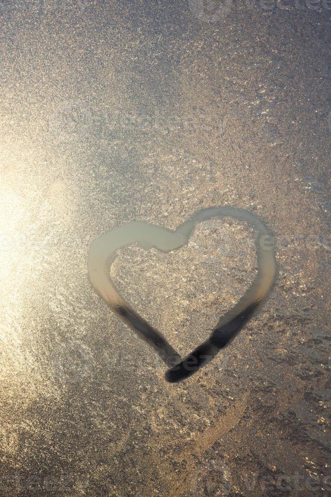 heart painted in winter on frozen glass, close up photo