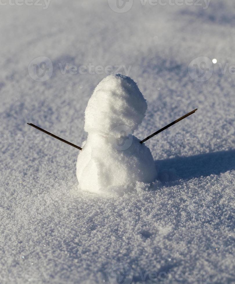 un pequeño muñeco de nieve en la temporada de invierno, de cerca foto