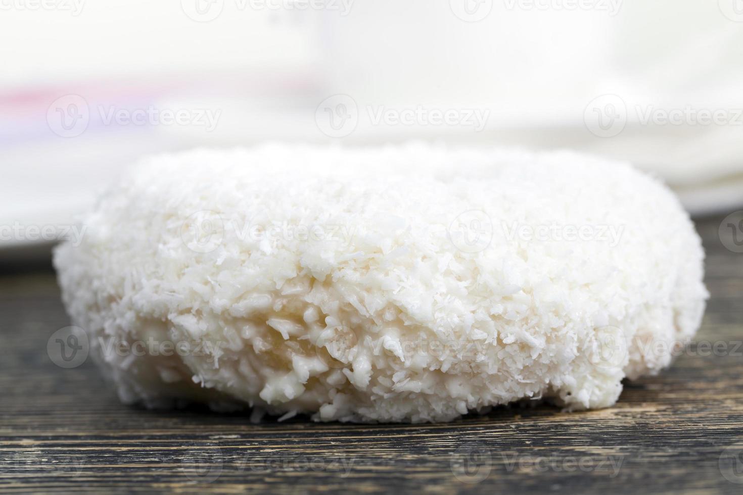 a fresh doughnut covered with white chocolate and coconut photo