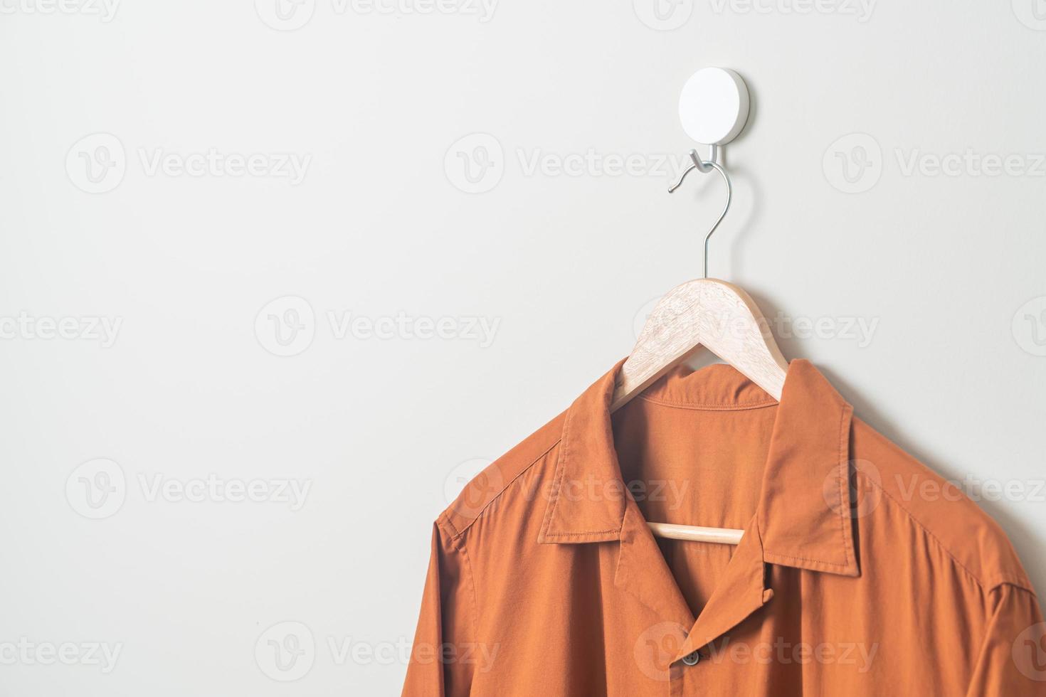 shirt with wood hanger on wall photo