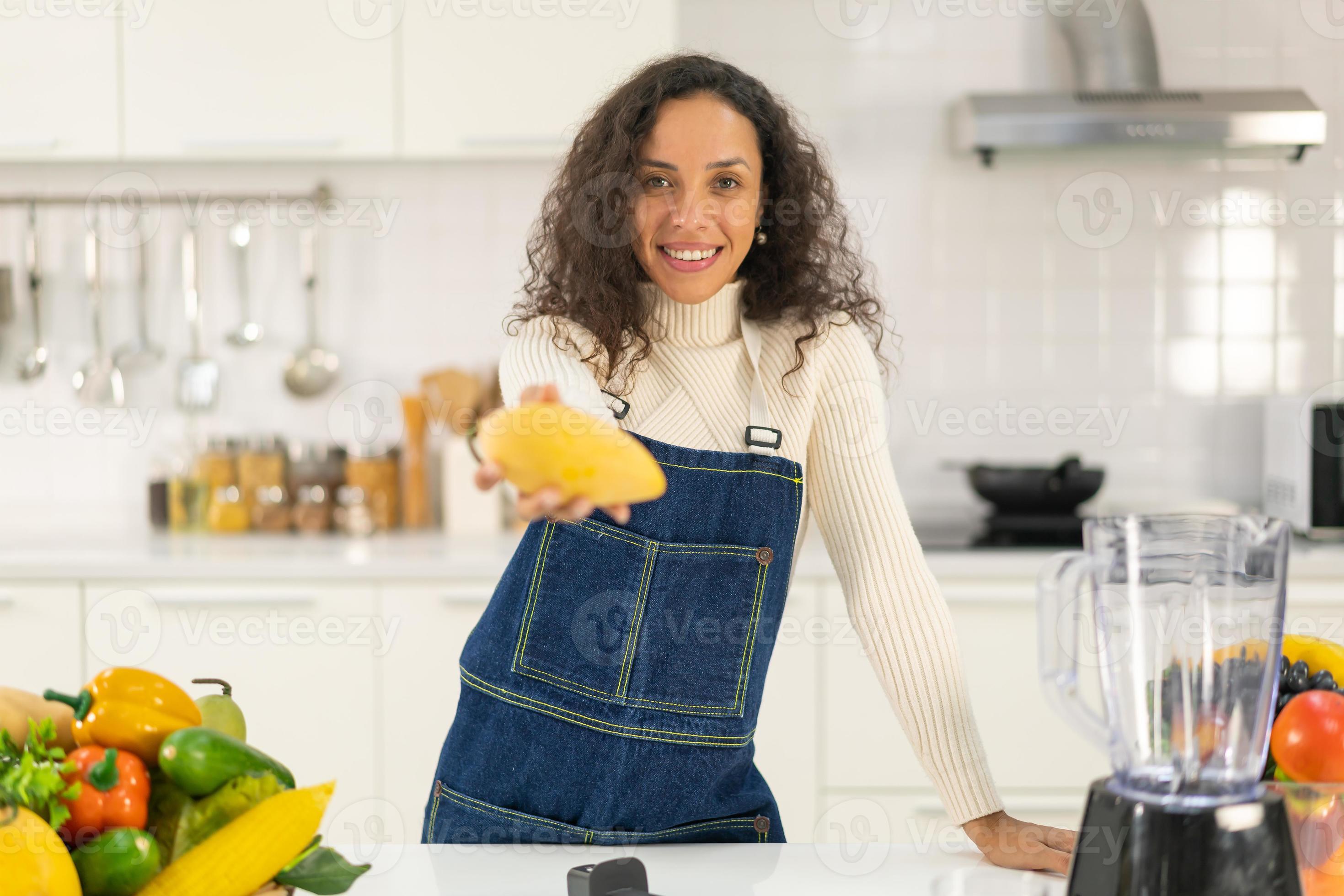 Latin woman making juice in kitchen 9724414 Stock Photo at Vecteezy