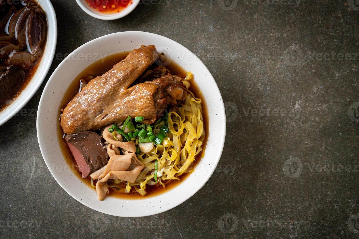 egg noodles with stewed and braised duck in brown soup photo