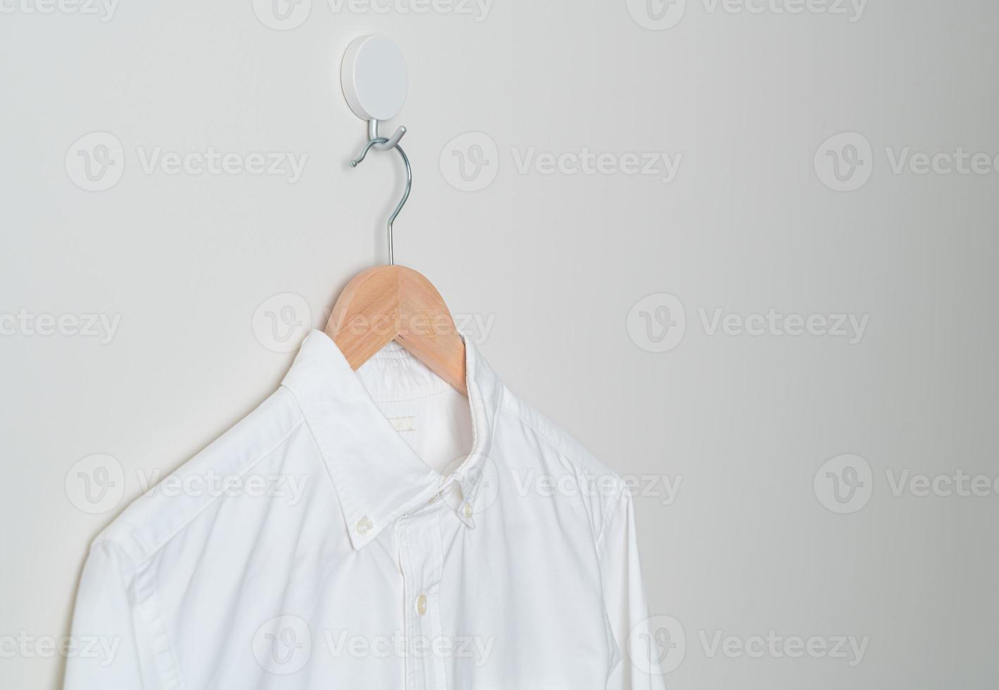 hanging shirt with wood hanger on wall photo