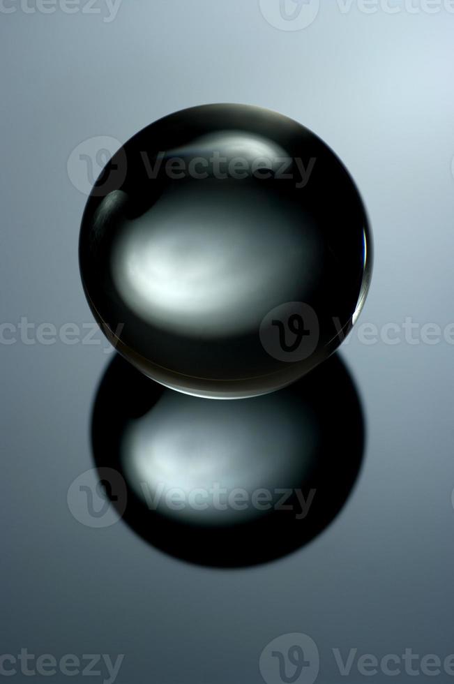 Abstract still life image of a glass ball in a low key. Geometric object with reflection, Glass sphere in a low key. photo