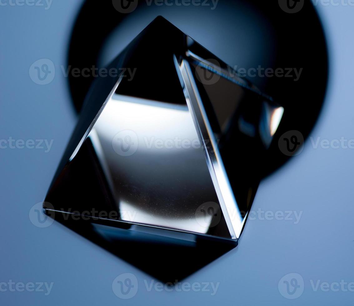 Abstract still life image with geometric objects. Glass pyramid in a low key. photo