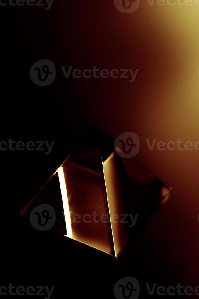 Dark abstract background with a shiy object. Glass object in the dark. photo