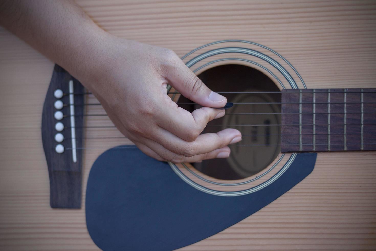 Hand of women holding guitar pick while playing music. photo