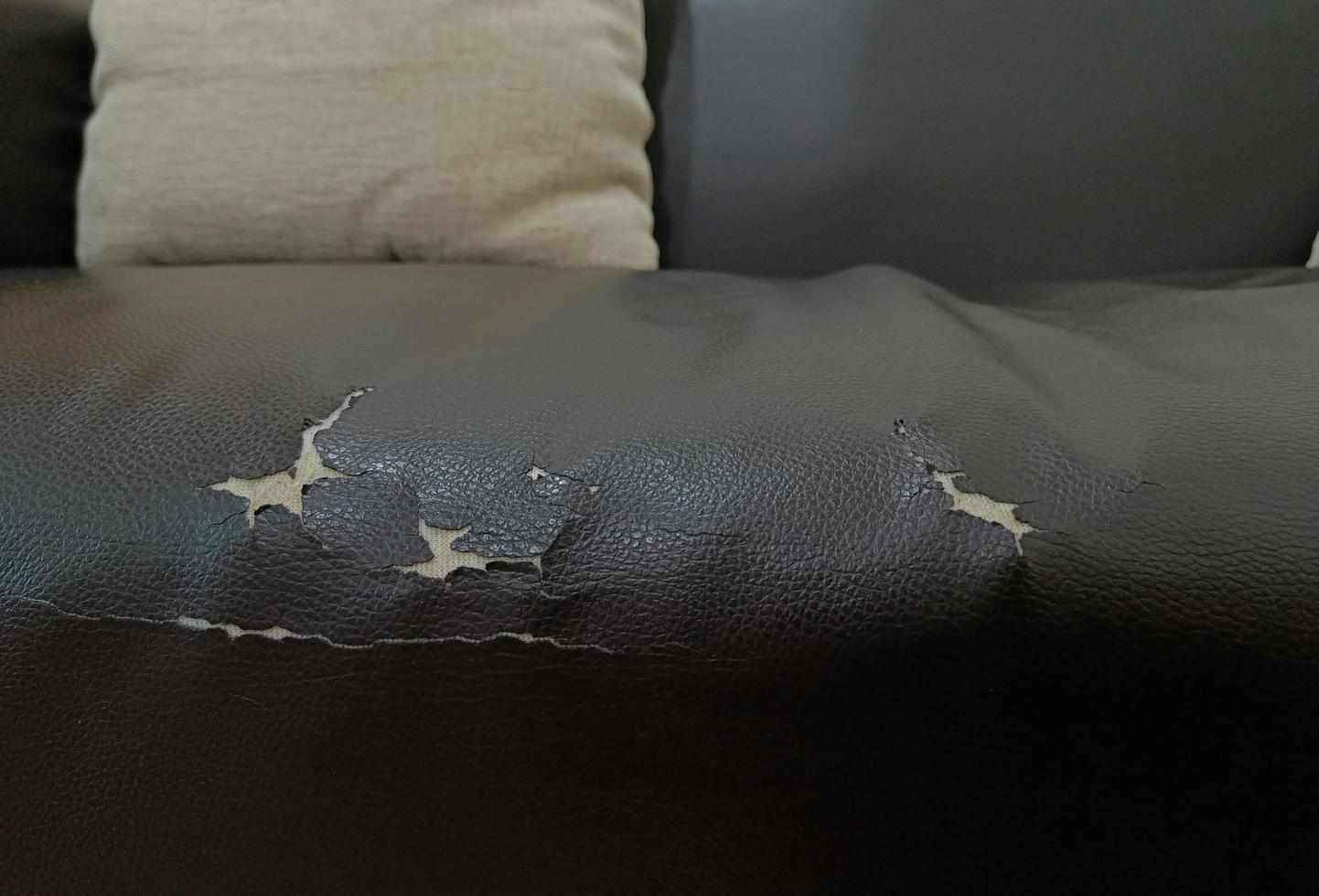 torn old leather black sofa. old leather seat lack from long service life photo